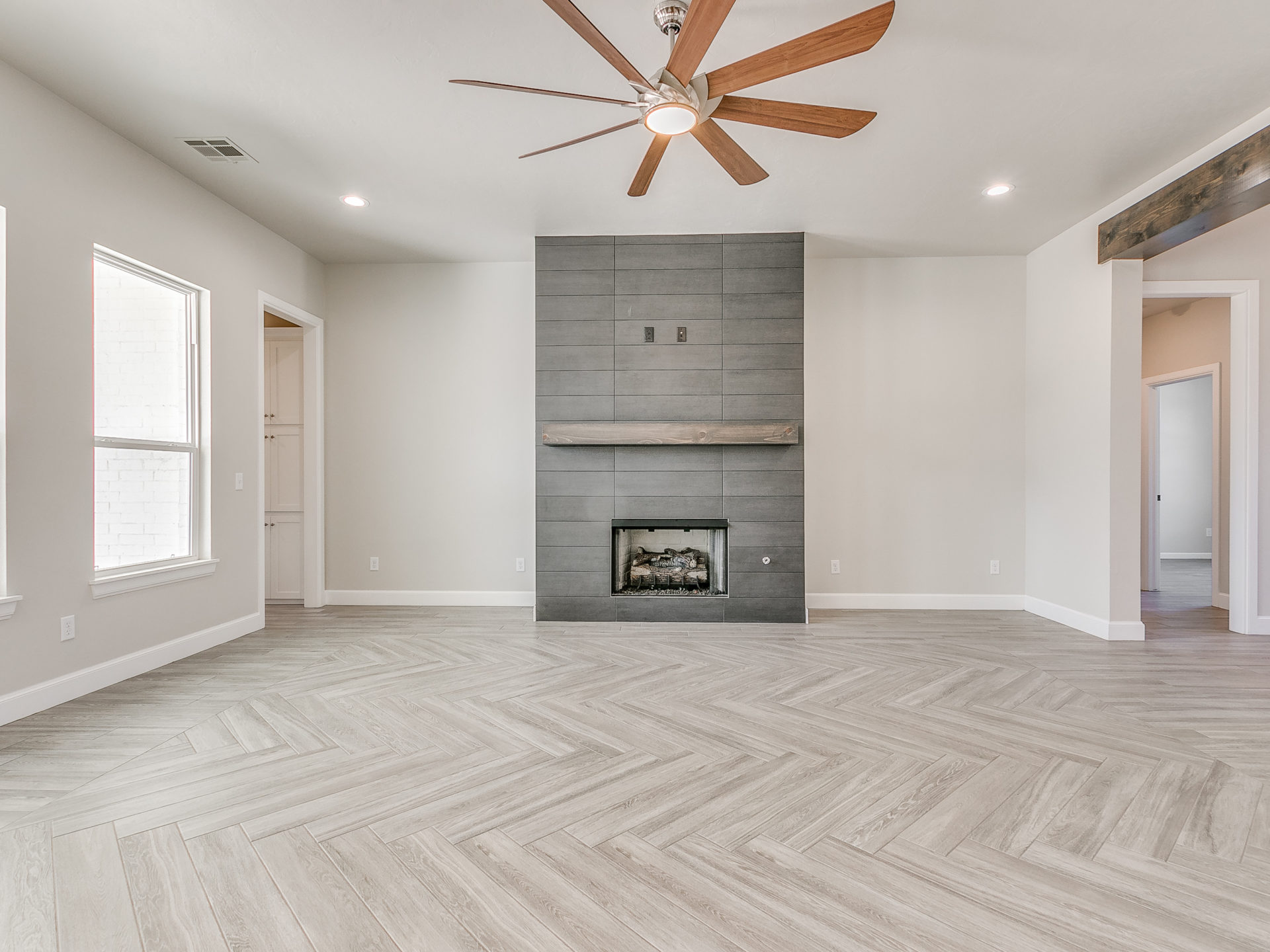 house interior, living room with modern fireplace and chevron wood flooring